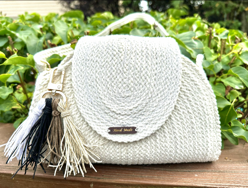 La Fundadora - satchel de cordón crema con tejido en espiral, asa dorada y pompón tricolor